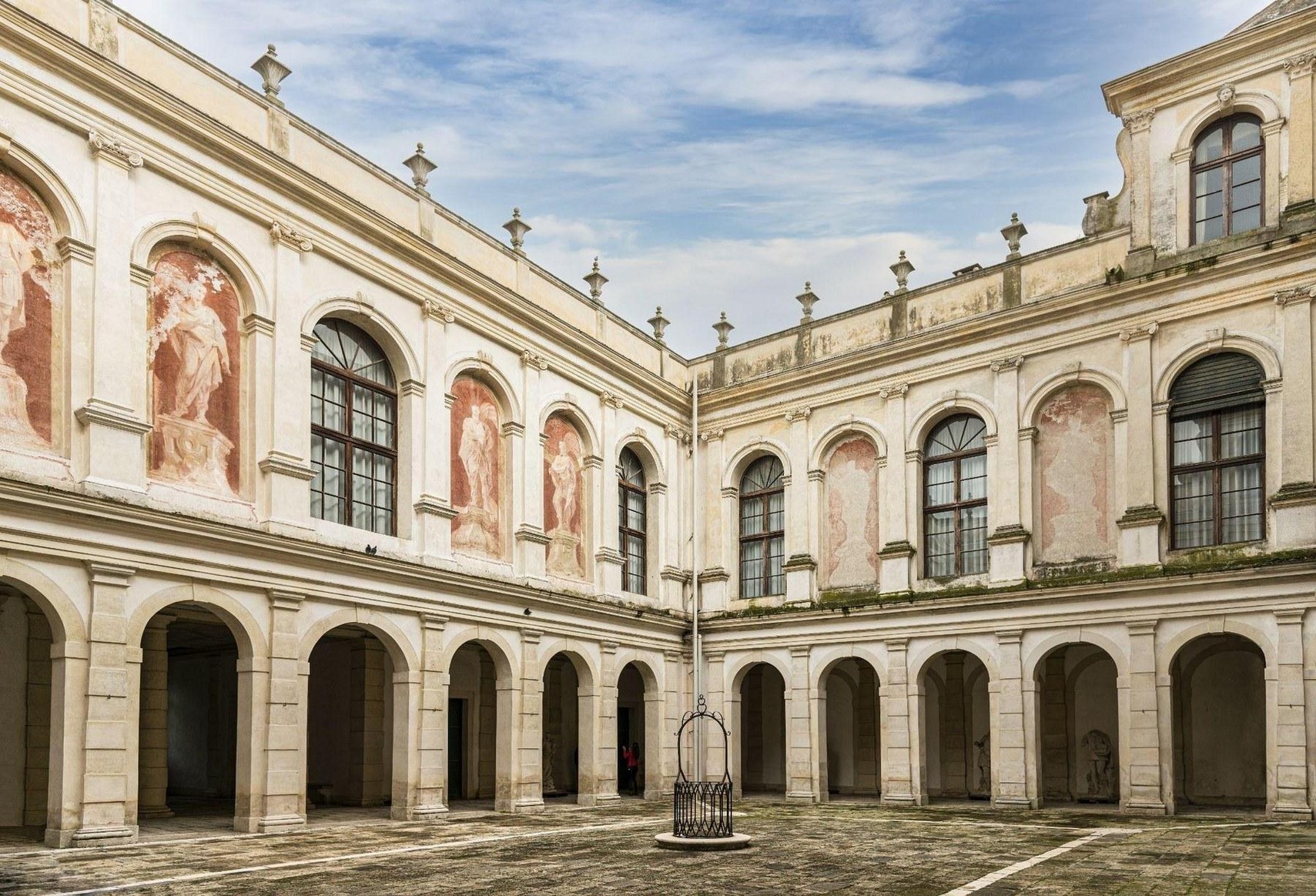 The inner courtyard, among frescoes and arcades: the coordinated work of many trades.